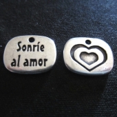 1 unidad. Colgante zamak Sonre al amor 15x11mm. Bao de plata